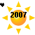 Pixelated sun icon with orange-yellow gradient center, black '2007' text overlay, and eight yellow triangular rays on white background; small black heart shape in top-left corner.