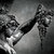 Monochrome pixelated image of a figure in dynamic pose with extended arm and blurred motion effect against gradient background.