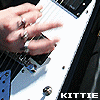 repeated motion-blurred images showing hands playing a white electric guitar with black and blue accents, each containing the text 'KITTIE' in white capital letters