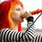 Pixelated image of a person with red and orange hair singing into a microphone, wearing a black-and-white checkered top.