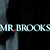 Pixelated text 'MR. BROOKS' in light blue with a red dot over the period, set against a dark background with gray vertical elements.