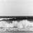 Two side-by-side pixelated images of a coastal scene with waves, one in grayscale and the other in color showing blue sky and water.