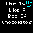 Pixelated text reads "Life Is Like A Box Of Chocolates" with a cyan heart symbol replacing the word "is" in one instance, displayed on black background.