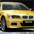 Static pixel art of a yellow sedan with dark windows, front grille, and headlights, viewed from a low angle against a dark background.