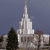 Pixelated image of a tall white building with a spire against a dark blue sky, surrounded by trees and smaller structures.