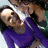 Two figures in close embrace, one in purple clothing, against a blurred background with light and dark tones.