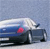 A blue car with a white roof and red taillight is shown in motion against a light blue background.