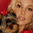 Static 48x48 pixel icon showing a close-up of a person with light brown hair holding a small dog against a red background, rendered in low-resolution pixel art style.