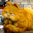 A pixelated orange cat with green eyes, curled in a relaxed pose against a blurred background of light and dark tones.