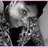 Black-and-white pixelated image of a person with patterned clothing, partially obscured by hand covering mouth, framed by pink border.