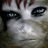 Pixelated close-up of a face with light skin, dark eyes, and brown hair against a muted background.