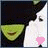 Pixelated cartoon character with dark hair and green face, white clothing, pink heart-shaped object in left frame, brown teardrop shape in right frame.