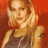 Static pixelated image of a person with long blonde hair wearing a dark sleeveless top against an orange background.