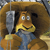 A cartoon character with large eyes and a wide mouth holds a silver microphone, set against a brown circular background.