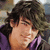 Pixelated close-up of a person with dark curly hair wearing purple clothing, face turned slightly right.