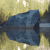 Pixelated blue and gray object with dark accents against a yellowish background, appearing as a stylized vehicle or mechanical shape.