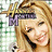 A pixelated image of a smiling person with blonde hair, wearing a purple 'Miley' headband, with text overlays changing across frames.