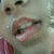 A close-up of a person's mouth and nose with lips parted, showing teeth in three