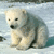 A polar bear sits on snow with pixelated text about global warming and saving lives.