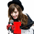 A person with long brown hair and a black beret holds a microphone, with red text overlays changing across frames.
