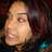 Pixelated close-up of a person's face with light skin tone, dark hair, and visible mouth showing teeth.