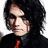Two side-by-side pixelated images of a person with long dark hair wearing a black shirt and red tie, showing different facial expressions.
