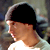 Static 50x50 pixel buddy icon showing a side-profile of a person with dark hair wearing a light-colored hoodie, set against a blurred background.