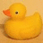 Yellow rubber duck with orange beak and black eye on beige background, next to yellow with red pixelated text "Rubber Ducks Rule!"