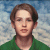 Pixelated portrait of a person with brown hair wearing a green shirt against a blue and white background.