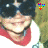 A person wearing dark sunglasses and a red scarf smiles in a pixelated image with small colorful icons above the head.