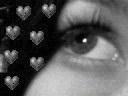 Black-and-white static icon featuring a close-up of a human eye with multiple heart symbols on the left side against a dark background.