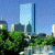 Pixelated cityscape with tall glass building, trees, and water under blue sky; green text 'Original Icons .com' on dark background.
