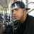 Pixelated image of a person wearing dark clothing and a cap, with light-colored hair visible on the sides.