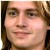 Pixelated close-up of a person's face with light brown hair and neutral expression, cropped to show forehead to chin.