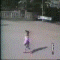 A child in a pink shirt and blue pants performs a sequence of movements including walking, bending, and falling on a paved surface with a small black-and-white post.