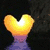 Animated heart-shaped sun over purple water with dark trees, transitioning to heart drawn in sand on beach, then palm tree silhouette at sunset.