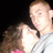 A pixelated image of two people in close proximity, one with short light hair wearing a gray shirt and the other with long brown hair in a pink top against a dark background.