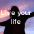 Silhouette of a person with arms outstretched against a sunset sky, text reads "Live your life" in white font.