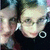 Two pixelated faces in close proximity, one with light hair and the other with dark hair, both wearing dark clothing against a blurred background.