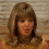 A four- shows a person with shoulder-length brown hair in a yellow top against a light brick wall, with subtle facial expression changes