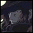 Pixelated image of a dark-cloaked figure with a pale face and visible teeth, next to stylized text on a black background.