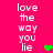 Bright pink background with repeated white text 'love the way you lie' and three pixelated heart symbols in green, brown, and olive green.