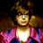 Pixelated static image of a character with dark hair, golden armor-like shoulder pieces, and pink-and-blue clothing against black background.