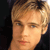 Pixelated close-up of a person with light brown hair against a dark background, showing facial features and partial neck.