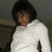Pixelated image of a person with short dark hair wearing a white shirt against a gray background.