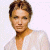 A pixelated image of a person with short brown hair wearing a white top against a light background, next to green text on dark green.