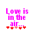 Pixelated text reads "Love is in the air..." with red and pink heart symbols below on a white background.