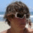 A pixelated beach scene with a person wearing sunglasses and green text overlay reading "OH YEAH hottie in some STUNNA SHADES!!".