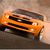 Pixelated orange car with black grille and headlights, angled view on brown background, no visible text or motion.
