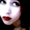 A static image of a person with dark hair and red lipstick, showing multiple facial expressions in a